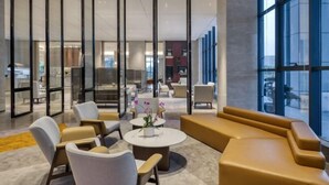 Un'accogliente hall moderna con zone relax, pareti divisorie in vetro e ampie finestre.