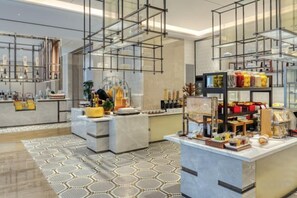A modern hotel lobby with a marble reception desk, a glass display case, and a patterned rug. - Crowne Plaza LANZHOU NEW AREA by IHG (Gaolan)