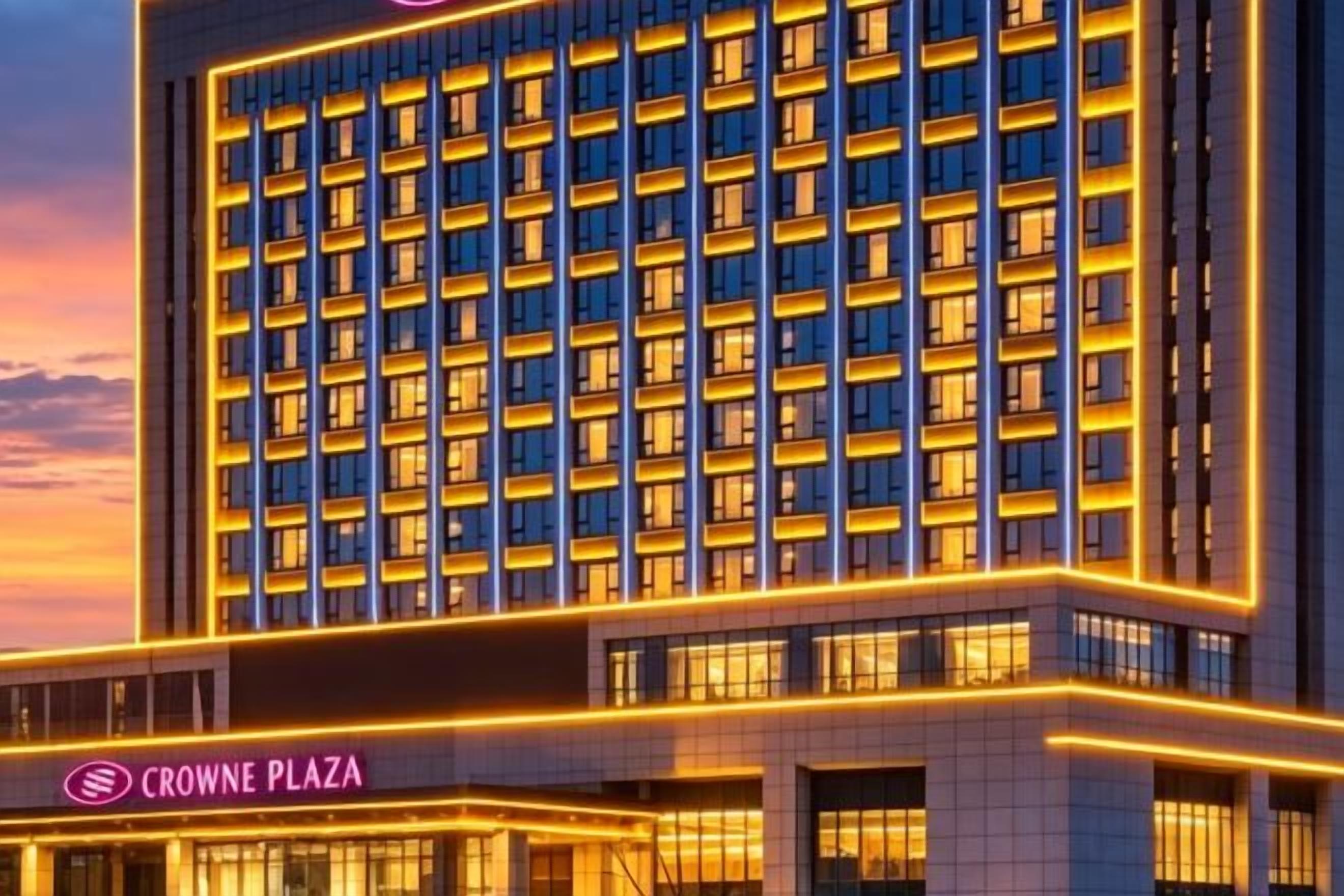 A multi-story hotel with a prominent sign reading 'CROWNE PLAZA' at the ground level.