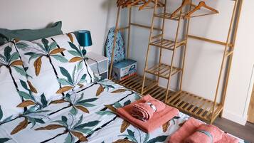 Chambre avec lit double, fer et planche à repasser, penderie avec ceintres