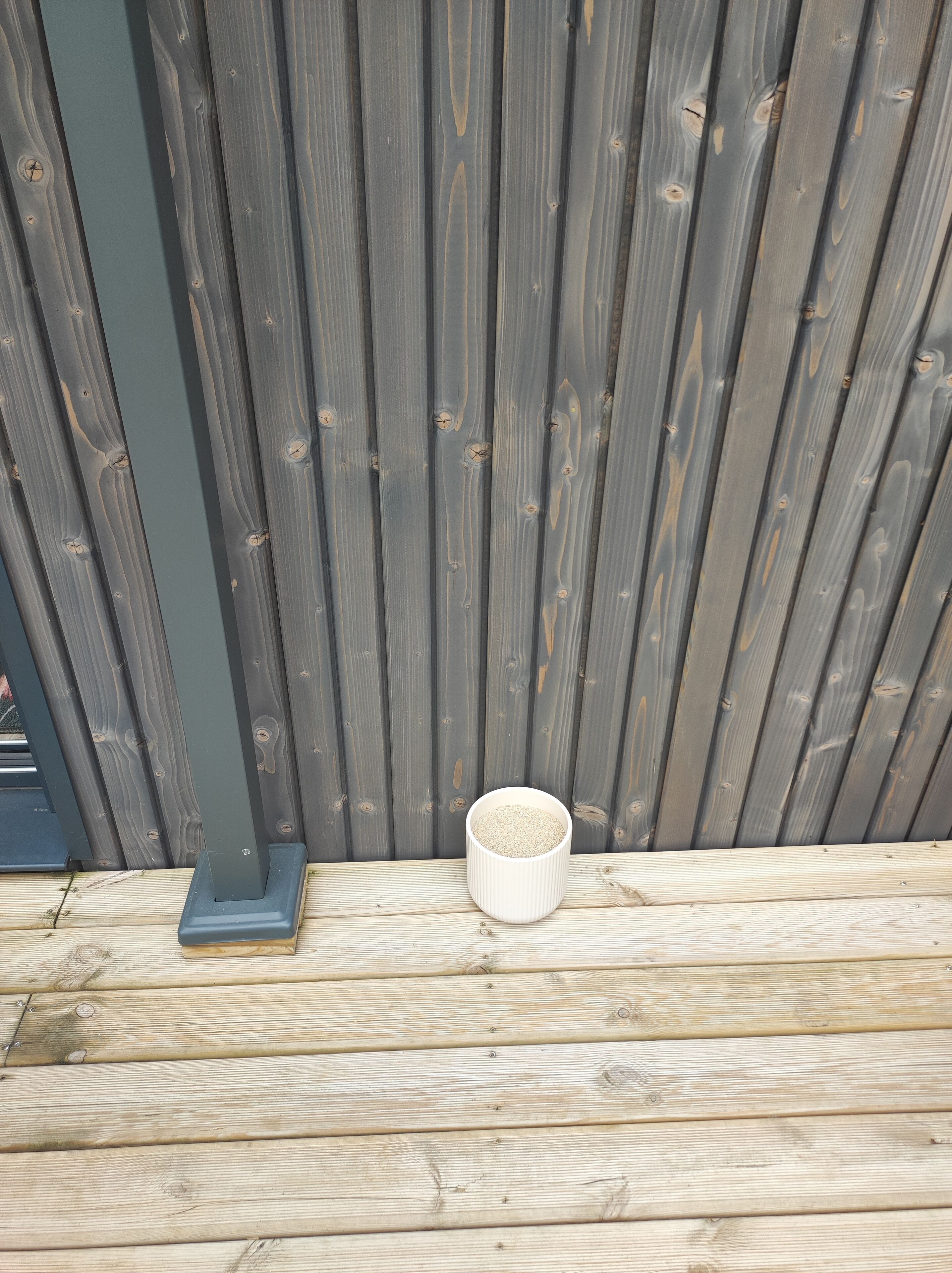 A wooden deck with a white bowl on it.