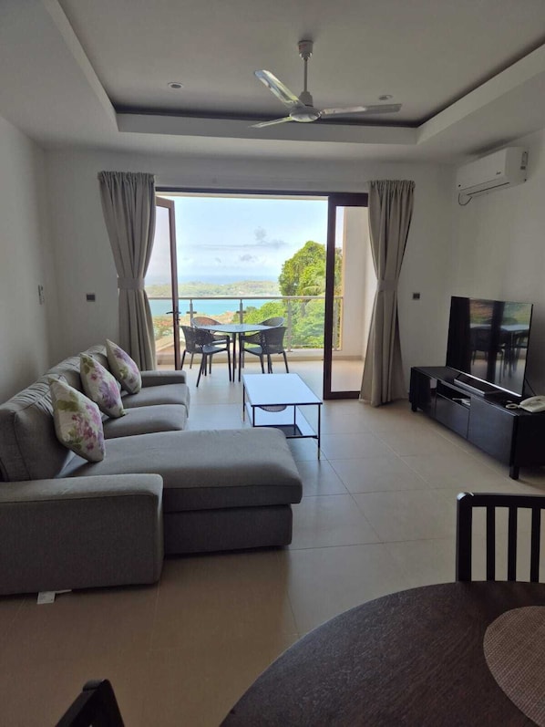 Leilighet – deluxe, havutsikt, ved fjell | Oppholdsområde | En 55-tommers LED-TV med kabel-kanaler samt leker