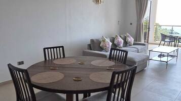 Deluxe-Apartment, Meerblick, Bergseite | Essbereich im Zimmer