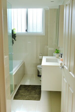 A bathroom with a bathtub, toilet, and sink. - Modern Poolside Coogee Beach Sanctuary (Sydney)