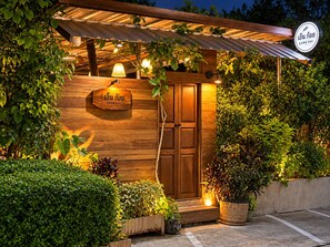 A wooden building with a sign that reads 'EARN KOIN' and a door. There are plants and a light fixture above the door. - CHERN CHIANGMAI BOUTIQUE (Chiang Mai)