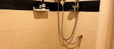 Un baño pequeño con inodoro, ducha y un perchero para toallas.