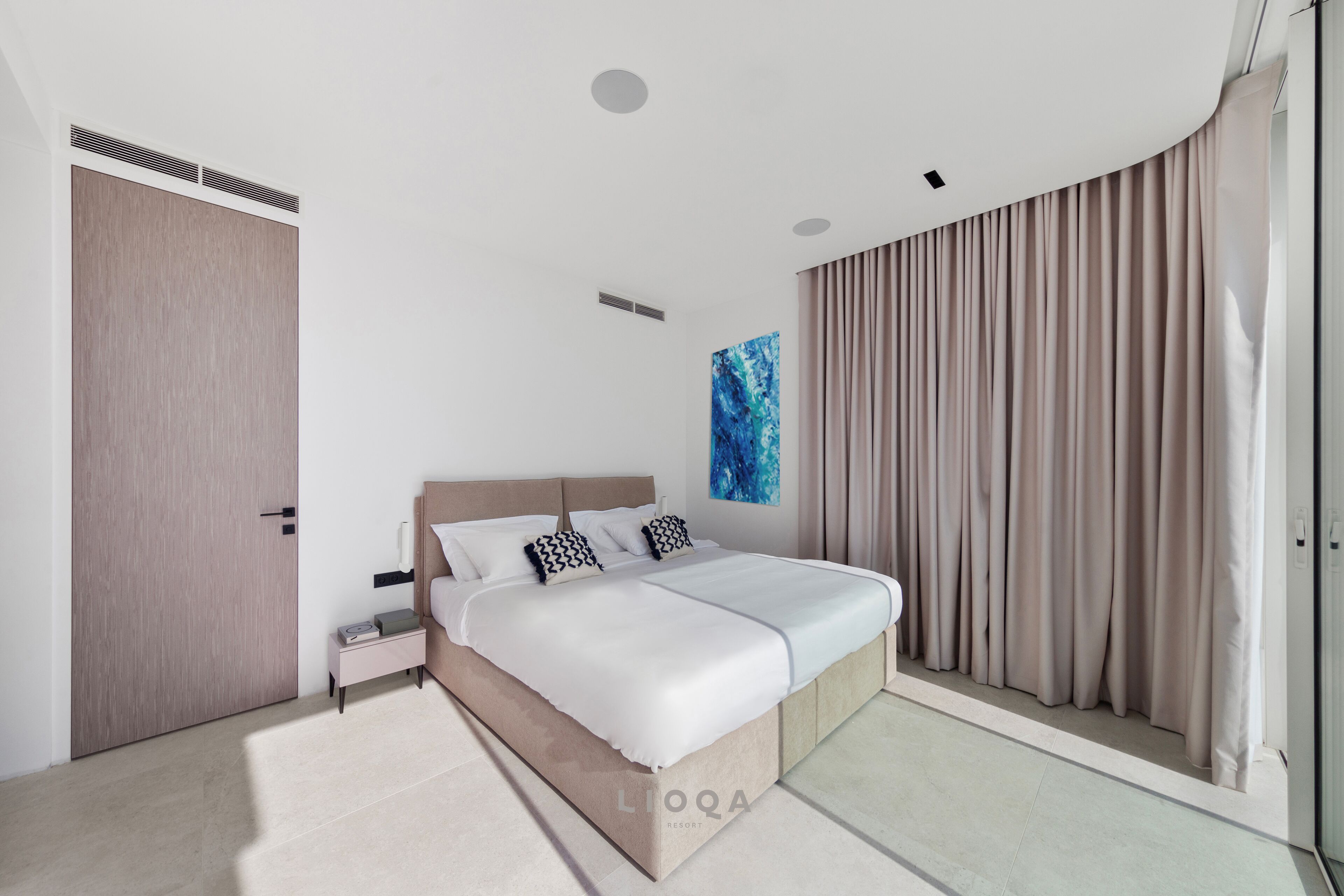 A modern bedroom with a large bed, a nightstand, a wardrobe, and a painting on the wall.