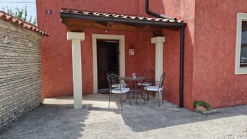 Enjoy a casual meal in this charming outdoor seating area with a small table and chairs.