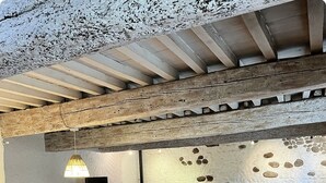 Ein rustikales Interieur mit Esstisch, Stühlen, einer Couch und einem Fernseher.