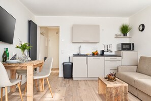 Ein modernes Wohnzimmer mit Essbereich, Küche und Sitzgelegenheit.