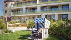 Un hôtel au design moderne, avec une structure à plusieurs étages dotée de balcons et d’une tour distinctive qui ressemble à un phare.