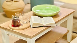 A wooden table with a book, a glass, and a teapot. - Bright Top-Floor Suite with Large Rooftop Terrace and Harbor View (Rankwitz)