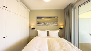 A bedroom with a bed, two bedside lamps, a painting, and a view of the outdoors. - Spacious Top-Floor Suite with Large Rooftop Terrace – Ideal for Families (Rankwitz)