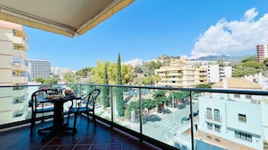 Enjoy the urban view from this balcony with a glass railing and tiled floor, perfect for taking in the sights of the surrounding city.