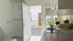 Une cuisine équipée d’un four à micro-ondes, d’une boîte en bois et d’une fenêtre avec des stores.