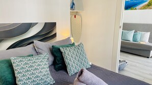 Une chambre à coucher moderne avec un lit, des oreillers et un canapé.