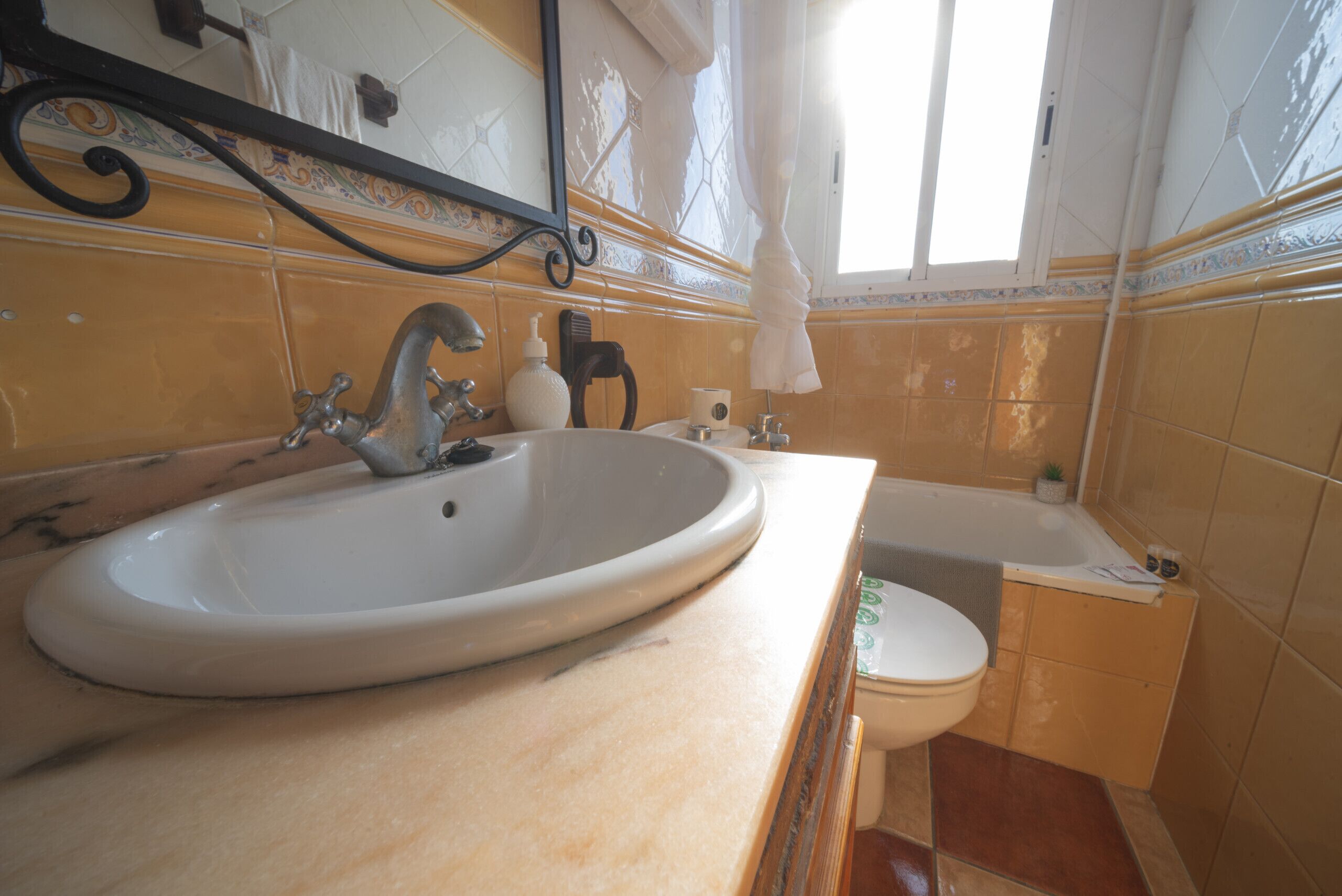 A bathroom with a sink, mirror, and bathtub.