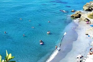 A beach with clear blue water, people swimming, and some on the shore. - StJimena Calahonda studio in the center of Nerja (Nerja)