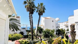 A residential area with white buildings, palm trees, and a clear blue sky. - Apartment Urb Laguna Beach Torrox Costa (Torrox Costa)