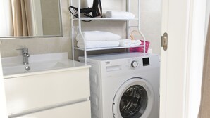 A compact bathroom with a washing machine, a sink, and a mirror. - Platero studio in the center of nerja (Nerja)