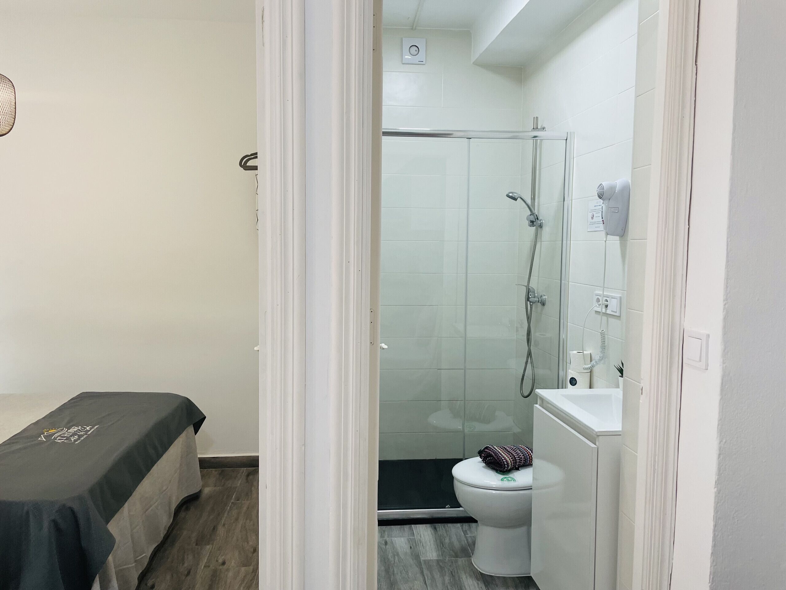 A small, modern bathroom with a shower, toilet, and sink.