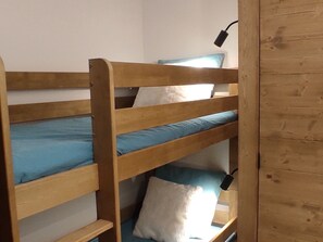 A bunk bed with blue bedding and a white pillow.