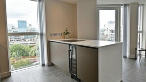 Eine moderne Küche mit einer großen Kochinsel, Blick auf die Stadt und minimalistischem Design.