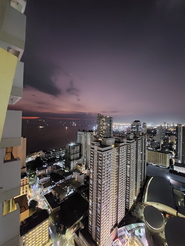 A high-rise building complex with multiple floors, large windows, and a view of the cityscape at night.