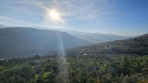 A mountainous landscape with a clear sky and sunlight.