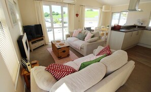 A cozy living room with a sofa, a television, and a small wooden table.