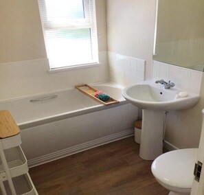 A bathroom with a bathtub, a sink, and a toilet.