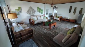 A living room with a sofa, a coffee table, and a lamp. - Beau Soleil Stunning Sea View  (Mahé Island)