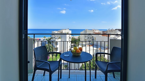 Ein Balkon mit zwei Stühlen, einem Tisch und einer Obstschale.