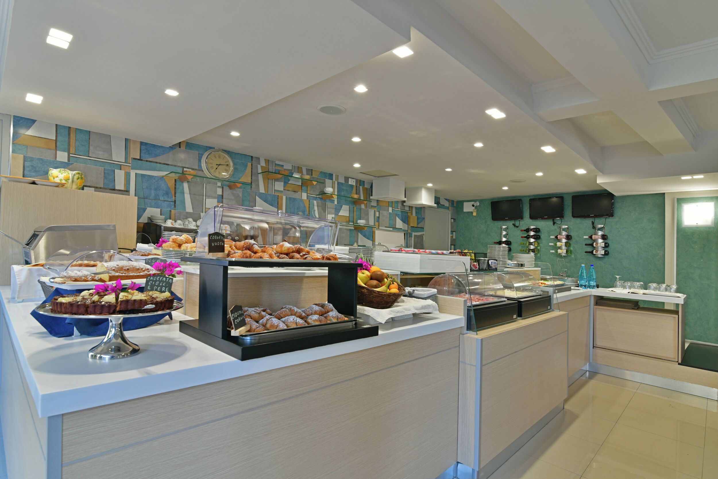 A buffet area with various food items and a clock on the wall.