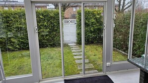 A modern room with a sliding glass door leading to a garden. - Unic House, Feeling Calmness in Malmo City (Malmö)