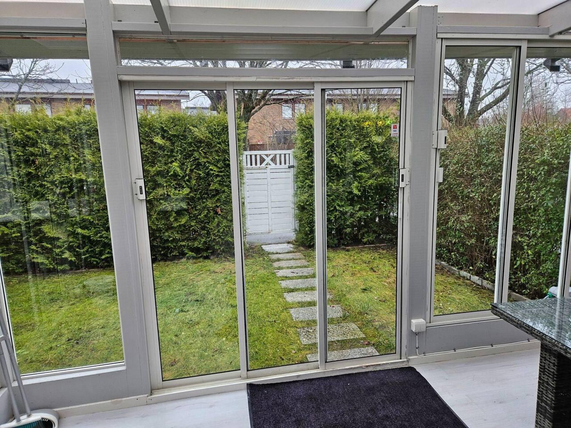 A modern room with a sliding glass door leading to a garden.
