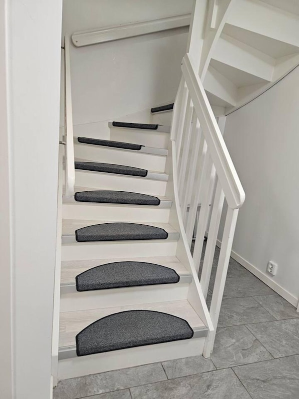 A white staircase with black treads and a white handrail. - Unic House, Feeling Calmness in Malmo City (Malmö)