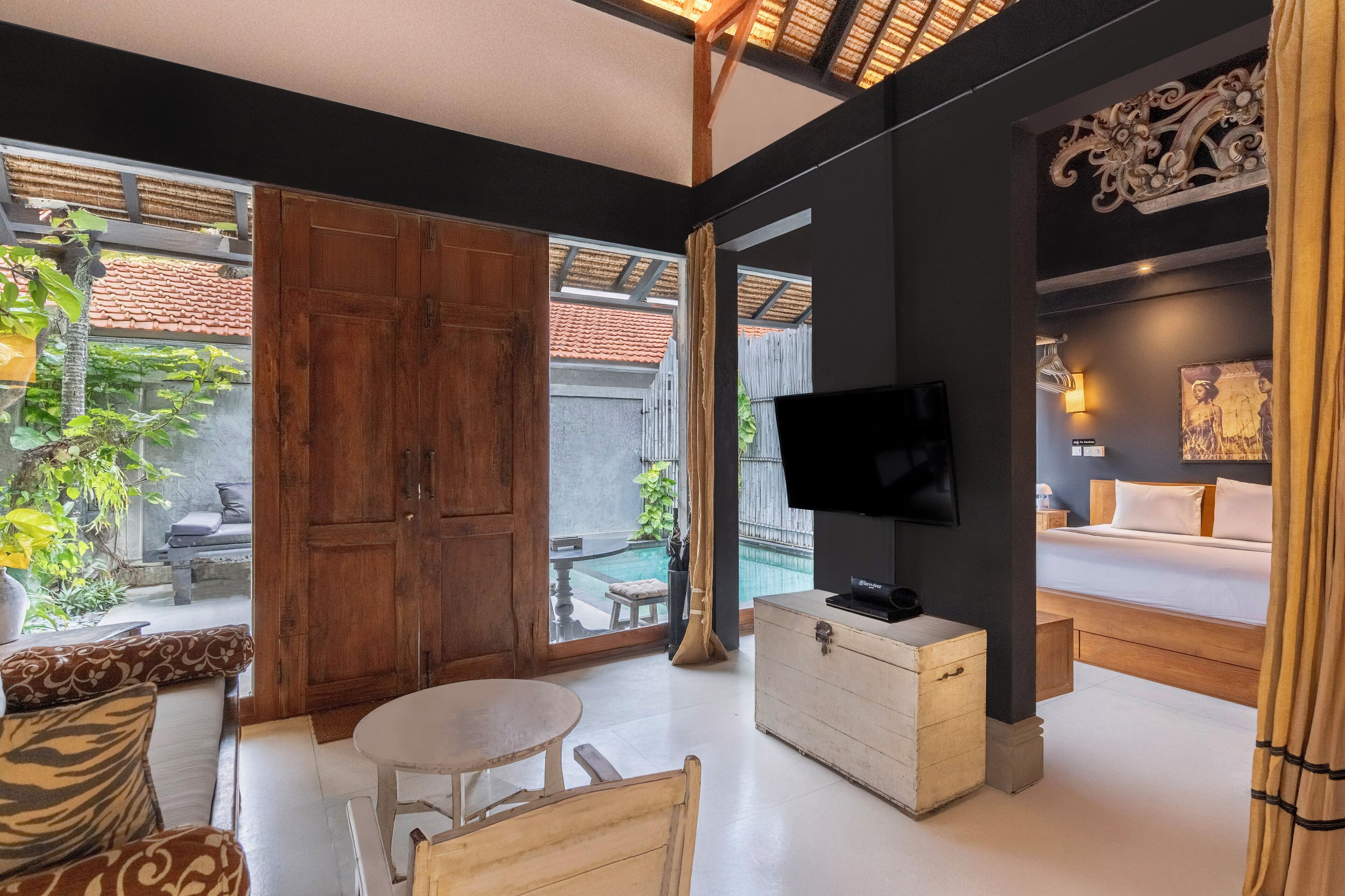 A modern living room with a sofa, a dining table, a TV, and a wooden cabinet.