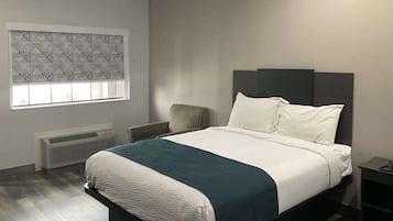 Een moderne slaapkamer met een groot bed, een radiator, een raam met zonwering en een stoel.