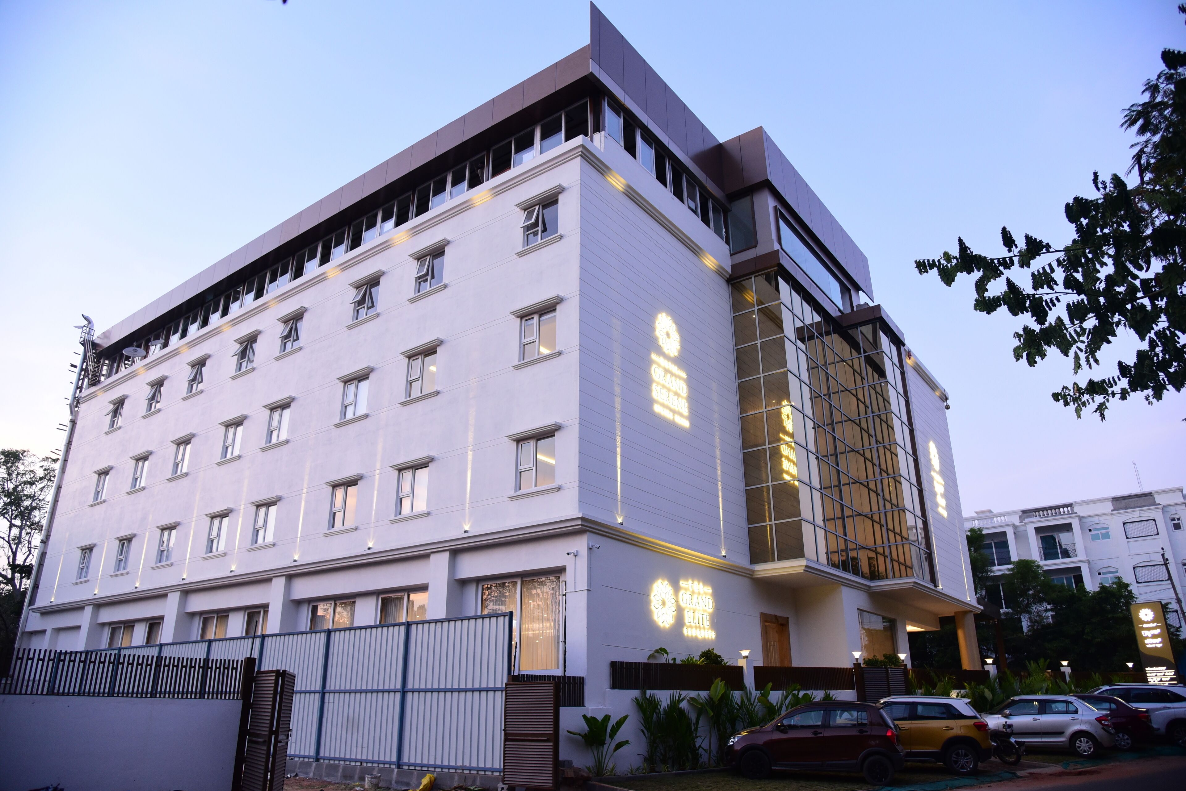Un hotel moderno con fachada blanca, numerosas ventanas y un letrero llamativo.