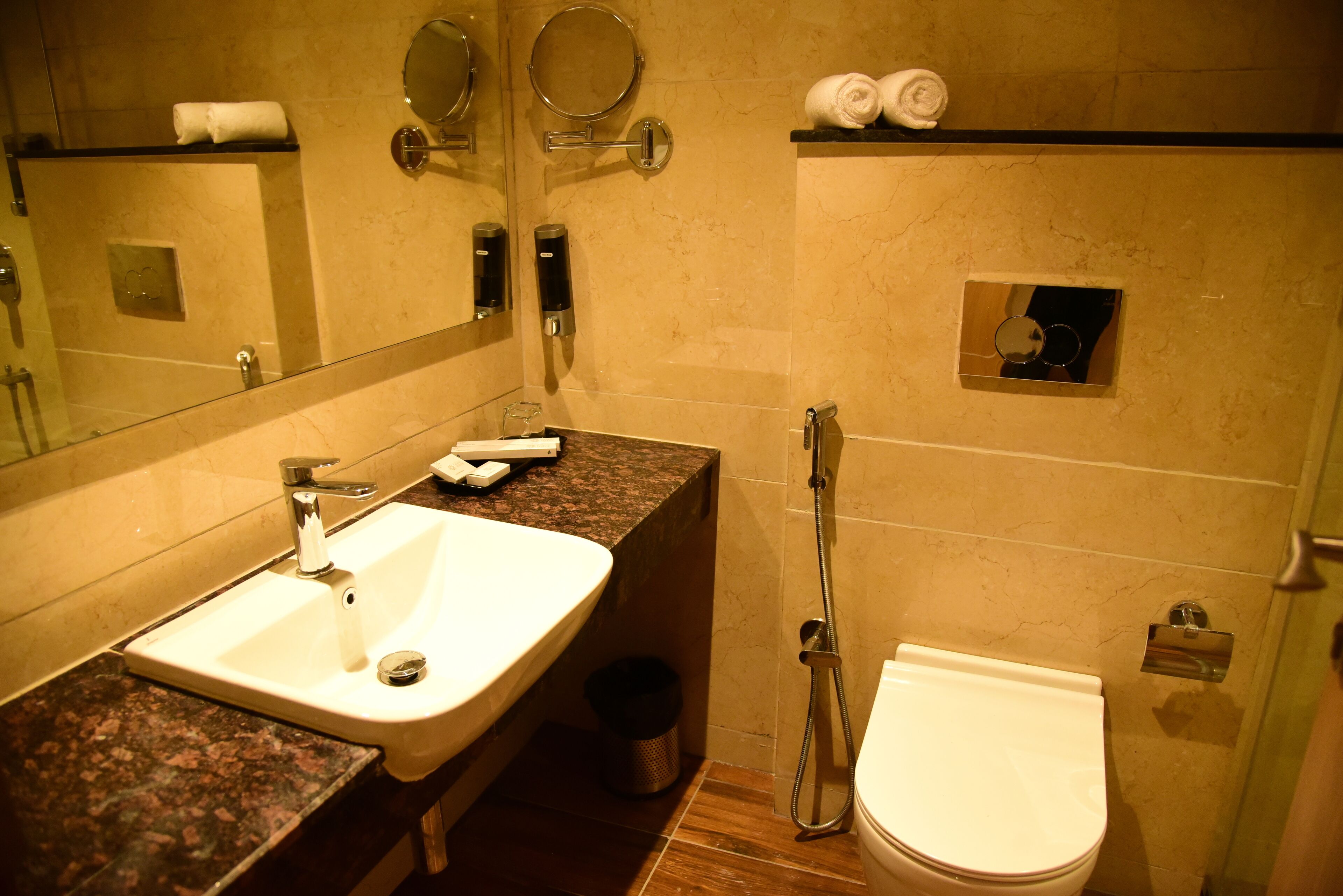 A bathroom with a sink, mirror, towel rack, and toilet.