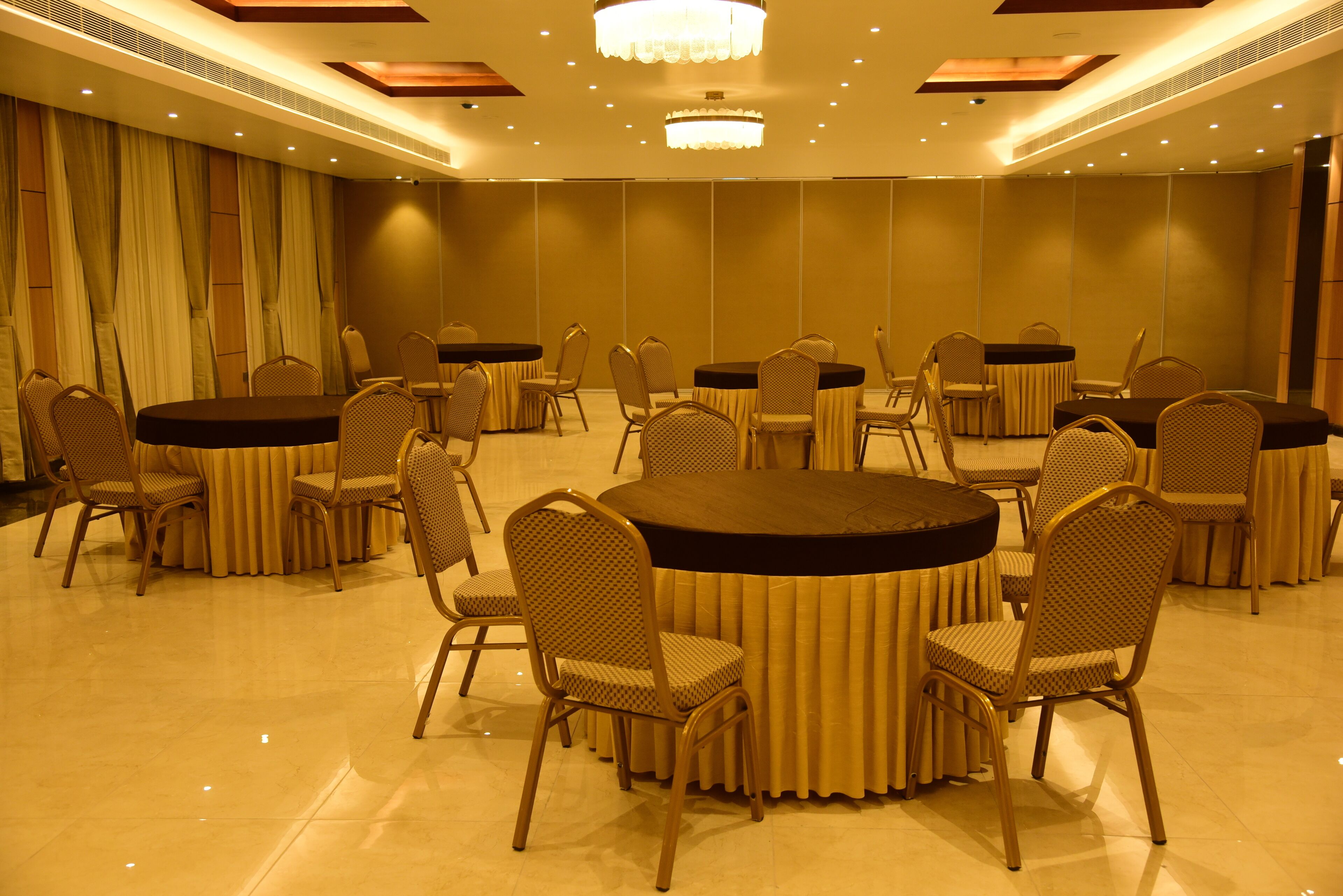 A conference room with multiple tables and chairs, arranged for meetings.