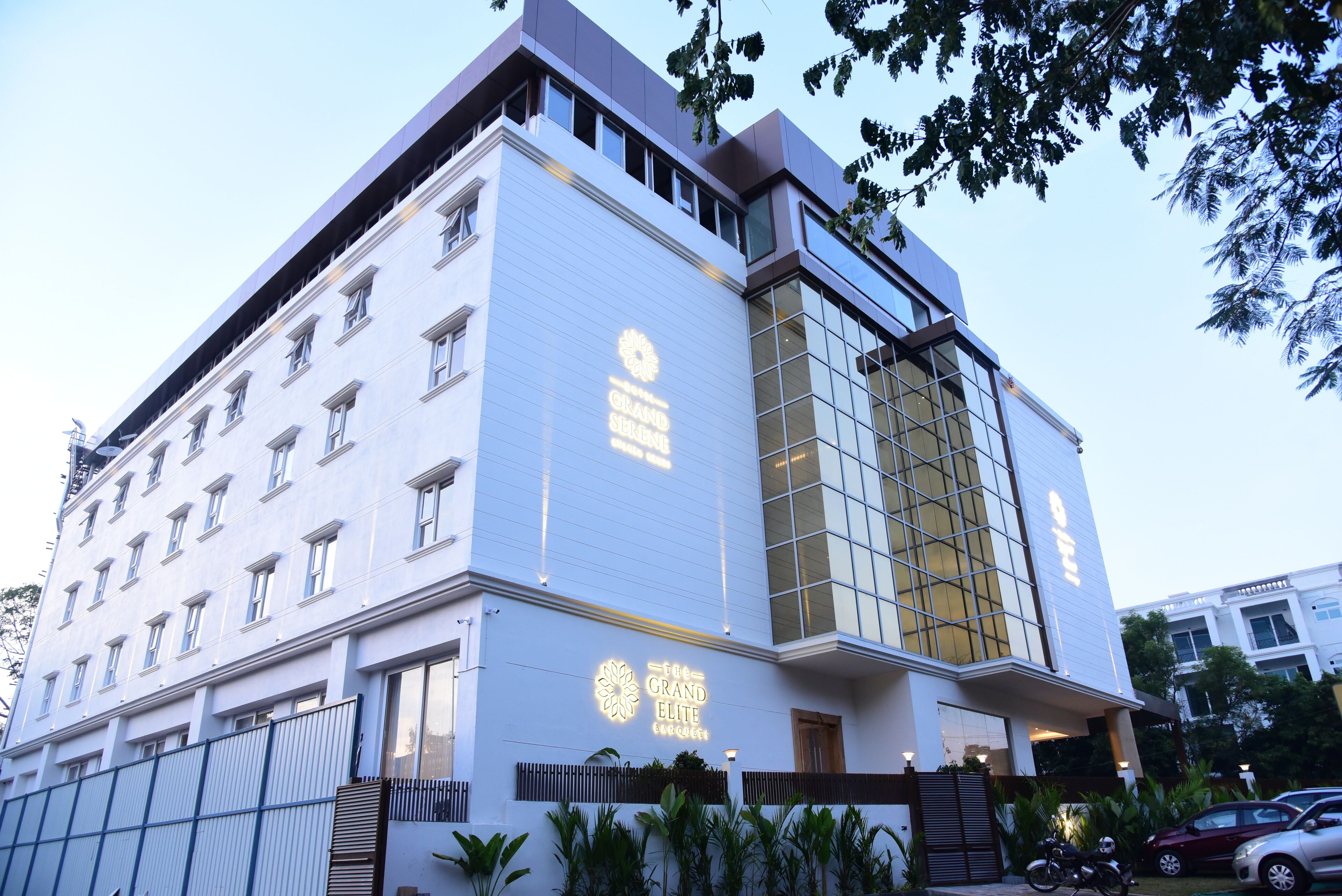 Een modern hotel met een opvallend bord waarop 'The Grand Elite' staat.