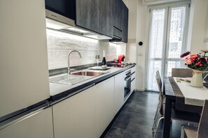 Een moderne keuken met een spoelbak, fornuis en een eethoek.