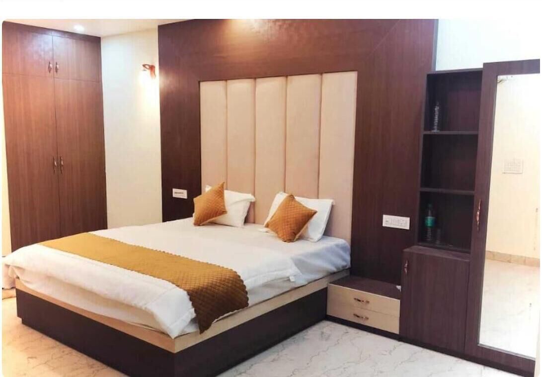 Une chambre à coucher comprenant un lit, une table de chevet, une armoire et une étagère intégrée.