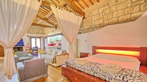 A cozy bedroom with a wooden headboard, a large bed with a patterned bedspread, and a wooden nightstand. - Suite Apartment Voltumna (Orvieto)