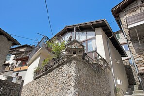 A stone building with a balcony and a small window. - Casa Lara (Lugano)