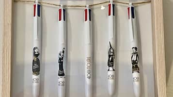A framed display of five white pens with red, white, and blue stripes, each featuring a different cartoon character and the text "400 MOURE".