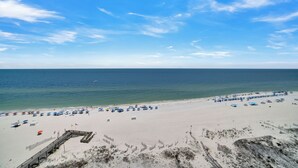 A beach with a wooden boardwalk, umbrellas, and beach chairs. - Phoenix IX 1101 by Liquid Life (Orange Beach)