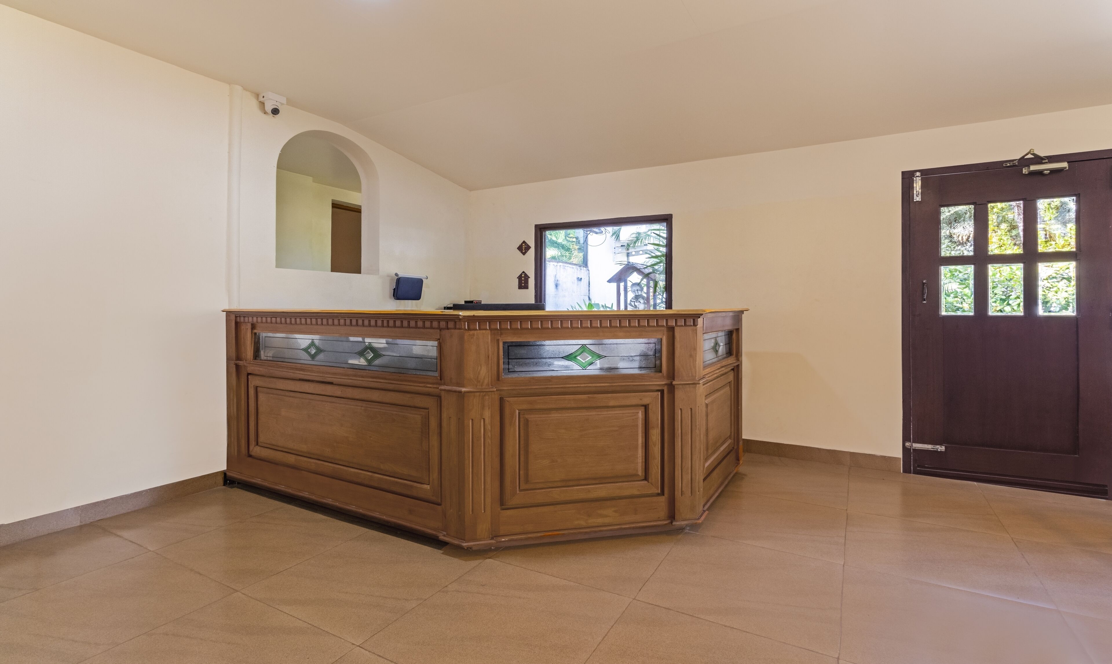 A reception desk with a mirror, a small blue bag, and a door with windows.